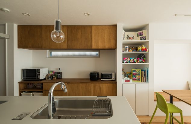 オーダーメイドのカップボードに裸電球のペンダントライトのあるキッチン　