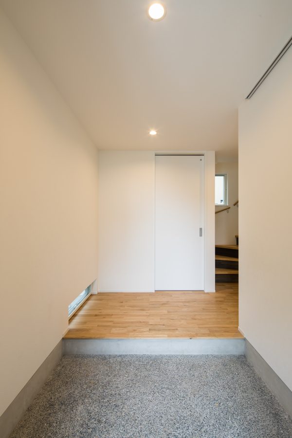 足元の窓から光が入るシンプルな玄関