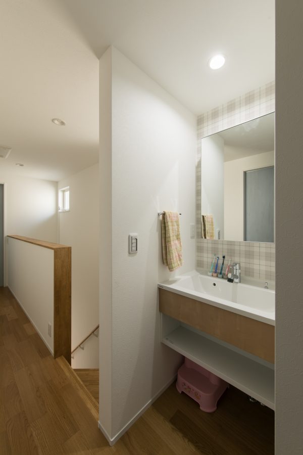 アクセントクロスと広く取った洗面ボールのある洗面台　