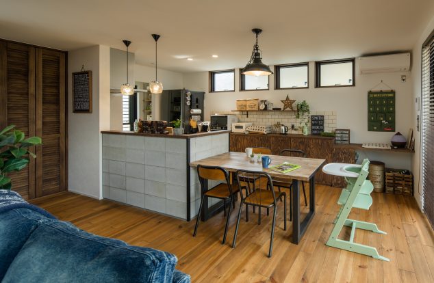 コンクリート調のキッチン腰壁にあわせた木とアイアンのダイニング