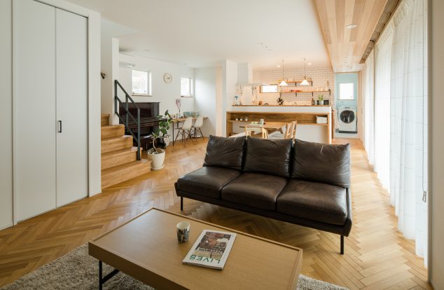 ヘリンボーンの床にスタディースペースのあるリビング