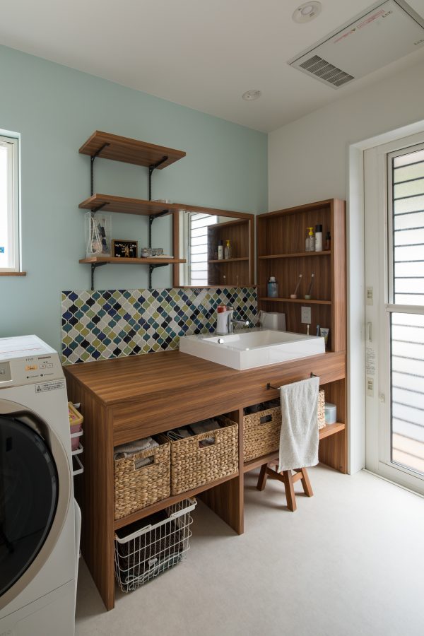 水色のクロスにアクセントでタイルを合わせた洗面所　