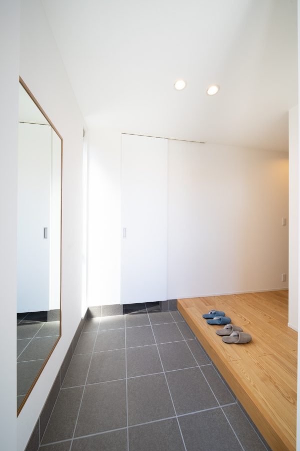 大きな鏡とシューズクロークとウォークインクローゼットが並ぶ玄関