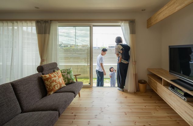 掃き出し窓から光が差し込む、やさしい木の色味のリビング　