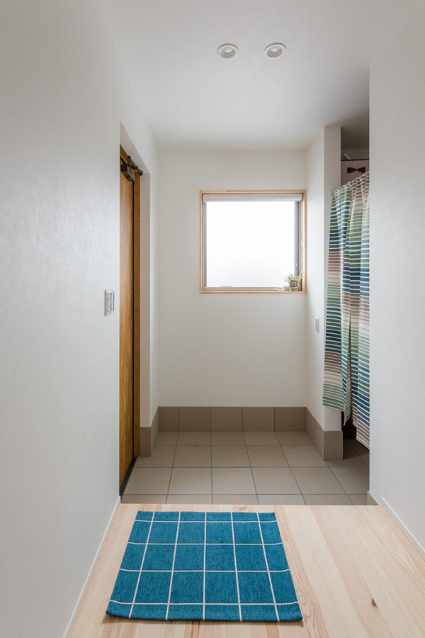 大きな窓からの光が迎えてくれる玄関　