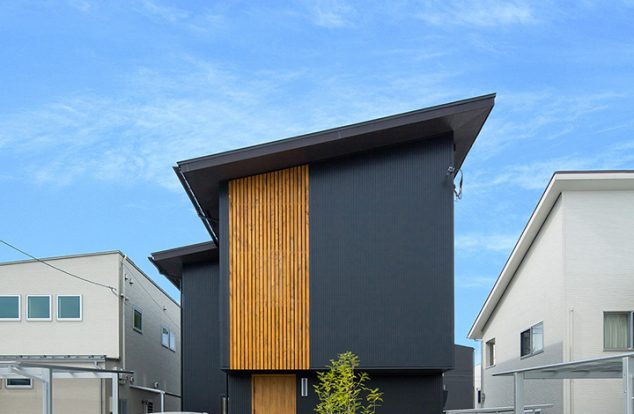 黒色ガルバリウムに格子をあわせ、大きな片流れの屋根をもつ外観　