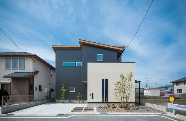 白塗り壁と紺ガルバのコントラストの家　