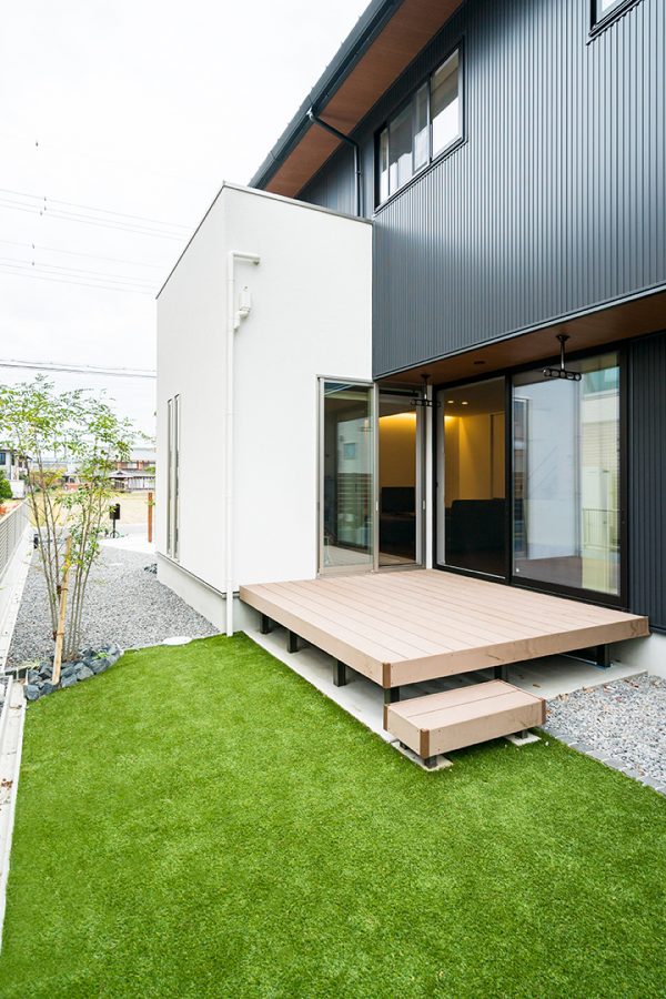 段差のあるウッドデッキと芝生の庭