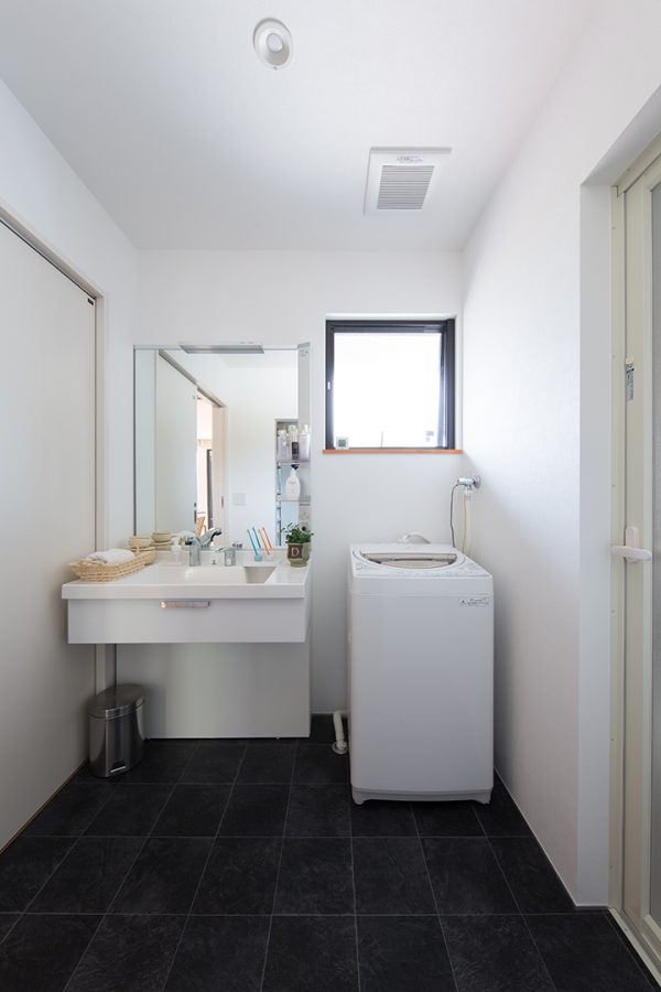 ネイビーのタイル調の床の洗面所　