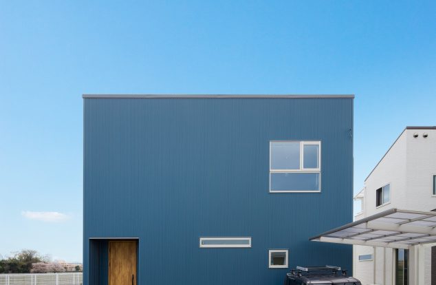 紺色ガルバリウムで窓を不規則に配置した箱型の外観　