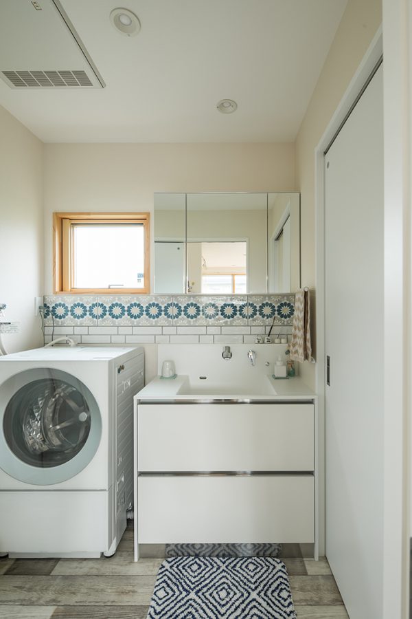 白い壁にかわいいタイルが映える洗面所　