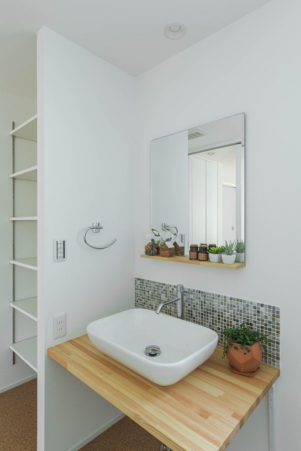 白壁にタイルと飾り棚が映える洗面所　