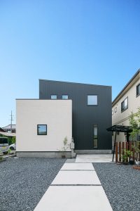 塗り壁とガルバリウムの組み合わせで四角い窓を散らした外観　