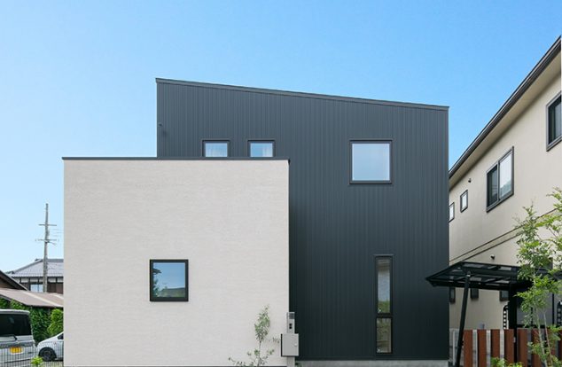 塗り壁とガルバリウムの組み合わせで四角い窓を散らした外観　