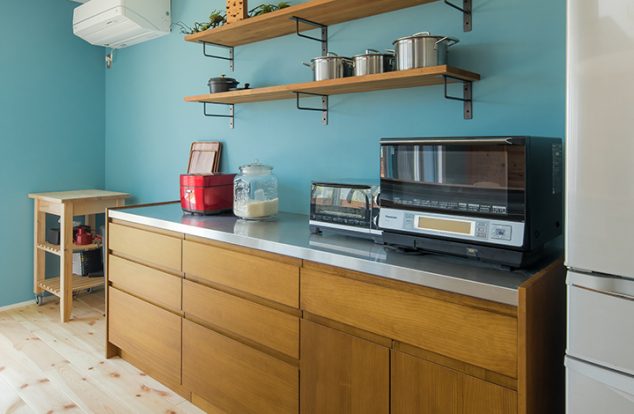 ブルーのアクセントクロスとオーダー食器棚のあるキッチン　