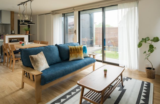 明るいナラの床に中庭からの光が差し込むリビング