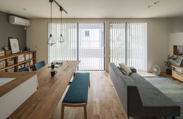 直線的に長い空間でグレーのアクセントクロスが映えるリビング