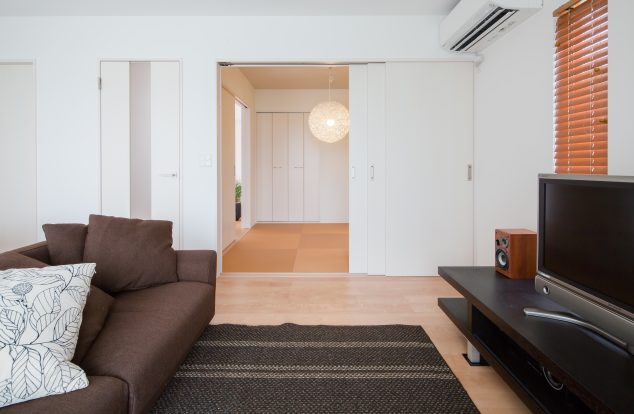 和室と一体感を持ってつながり、茶系で統一されたリビング　