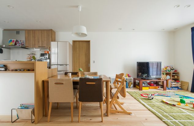 白ベースに落ち着いた色味でまとめ、カーテンでさし色をしたリビング　