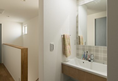 アクセントクロスと広く取った洗面ボールのある洗面台　