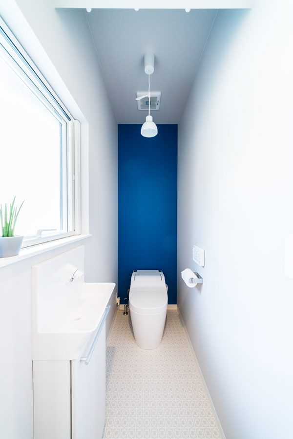 白い壁にブルーのアクセントクロスのトイレ　
