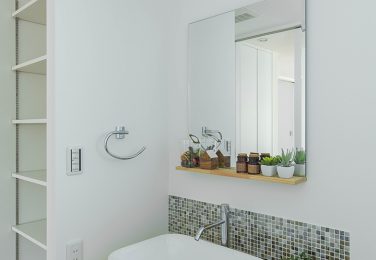 白壁にタイルと飾り棚が映える洗面所　