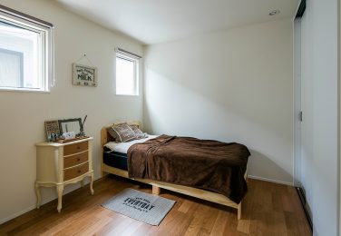 明るい木目調の床のある寝室